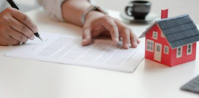 Close-up view of customer signing contract about home loan agreement, property real estate concept