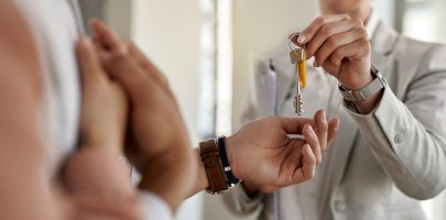 Close-up of a couple receiving keys of their new apartment from real estate agent.