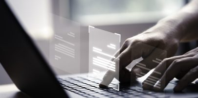 Hand using laptop computer with virtual screen and document for online approve paperless quality assurance and ERP management concept.