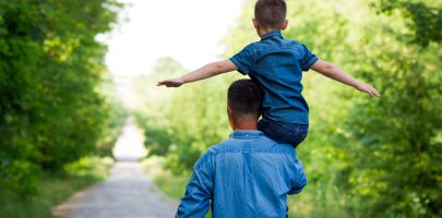 happy father and son walk along the road