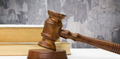 Wooden gavel and books on wooden table